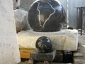 black marble ball with gray rock base