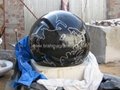 black marble ball with gray rock base