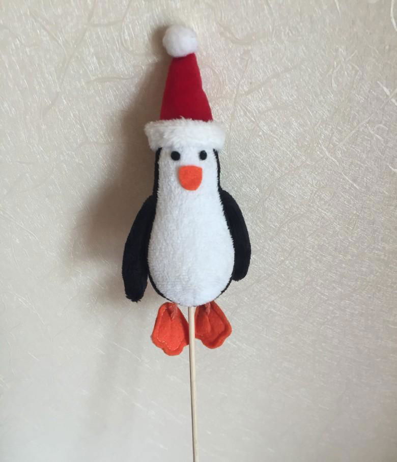 stuffed penguin with christmas cap and stick