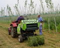 Round hay baler working for tractor