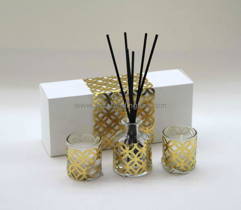 clear glass bottle wrapped with gold  laser cut paper and rattan sticks